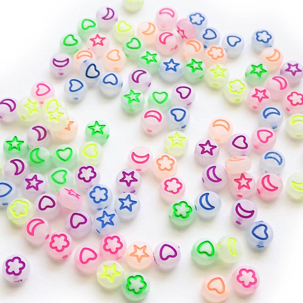 Star, heart, and moon designs on white glow round beads.
