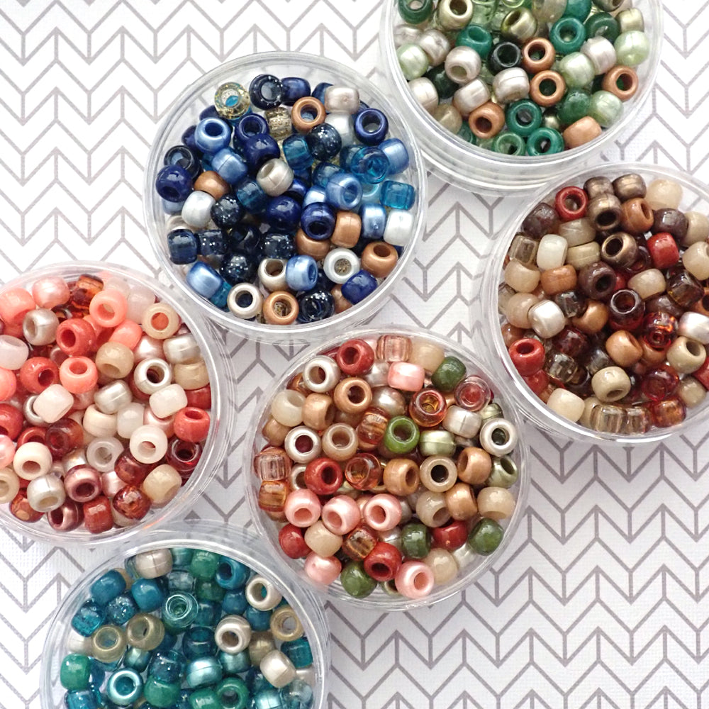Assorted Boho theme pony bead mixes  in clear containers on a white and gray patterned background