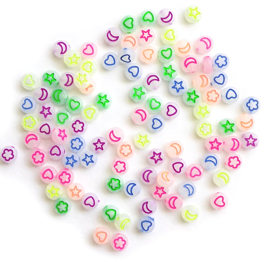 Star, heart, and moon designs on white glow round beads.