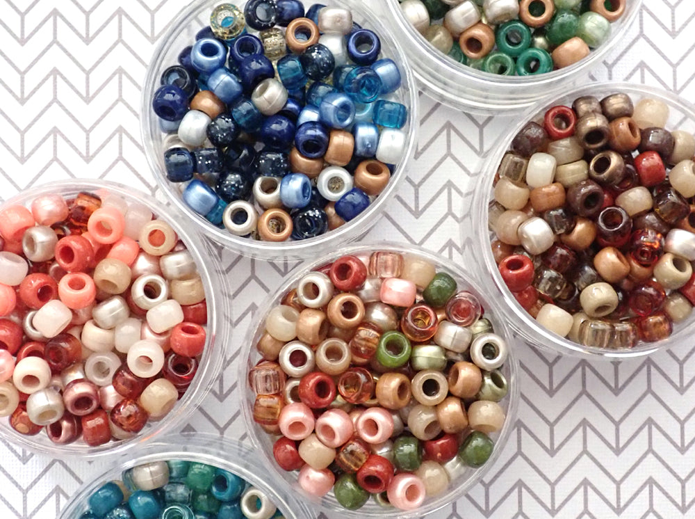 Assorted Boho theme pony bead mixes  in clear containers on a white and gray patterned background