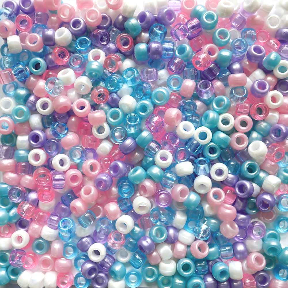 Assorted colorful pony beads in a mix of pink, blue, purple, and white.